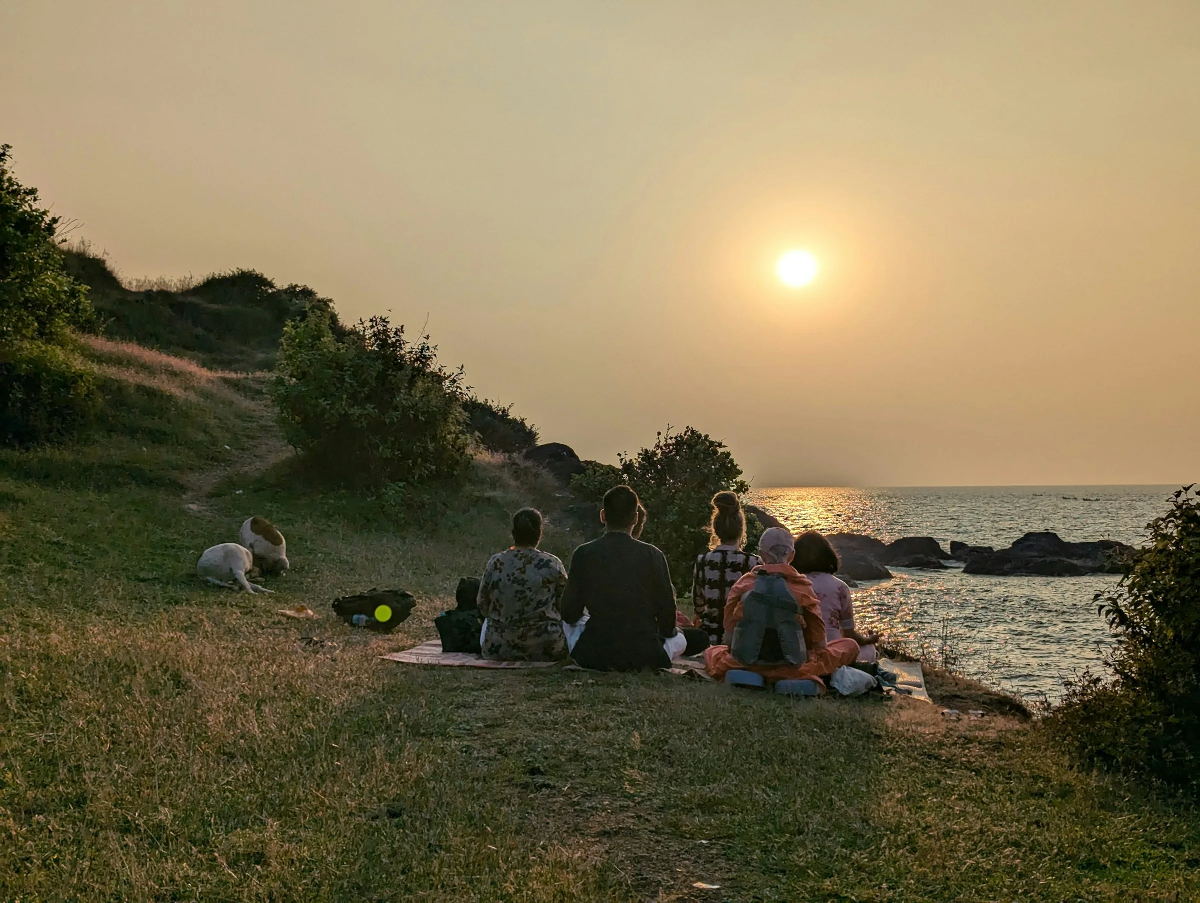 A coastal evening — figures gathered facing the horizon